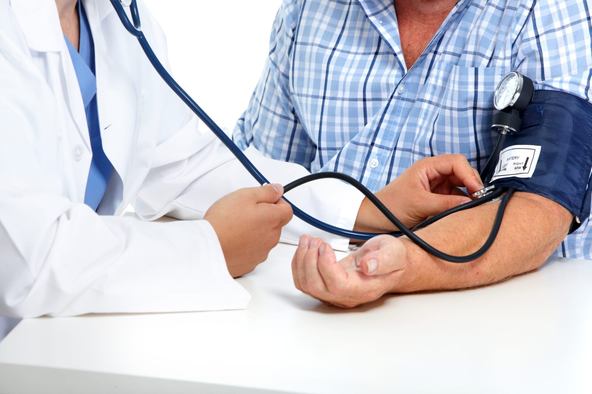 Close-up of a doctor using a stethoscope on a patient's arm to take a blood pressure reading