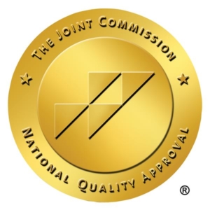 The Joint Commission National Quality Approval seal, a gold circle with four triangles inside