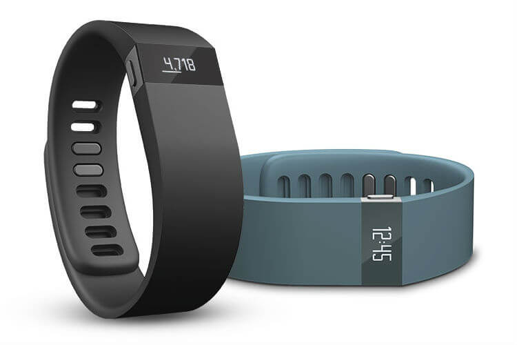 Two Fitbit health monitor wristbands, one black and one teal, on a white background.